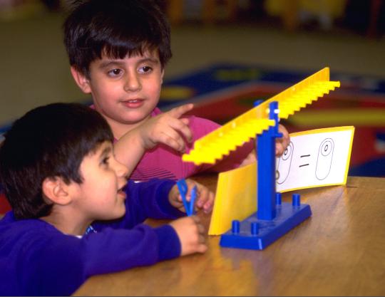 Young children discovering equals means balanced on a math balance