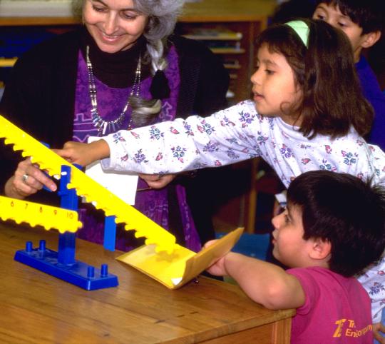 Visitor to MOVE IT Math Project GRAD USA being shown equals on math balance