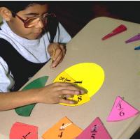 Grade 3 Hispanic boy exploring the meaning of fractions with fraction circles