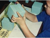 Grade 1 boy making a fair trade in base 3 with blocks that match up